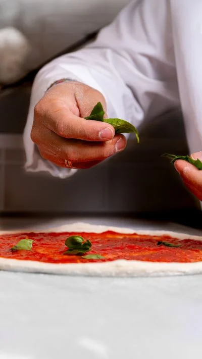Fresh sweet basil leaves placed delicately atop freshly crushed tomato sauce