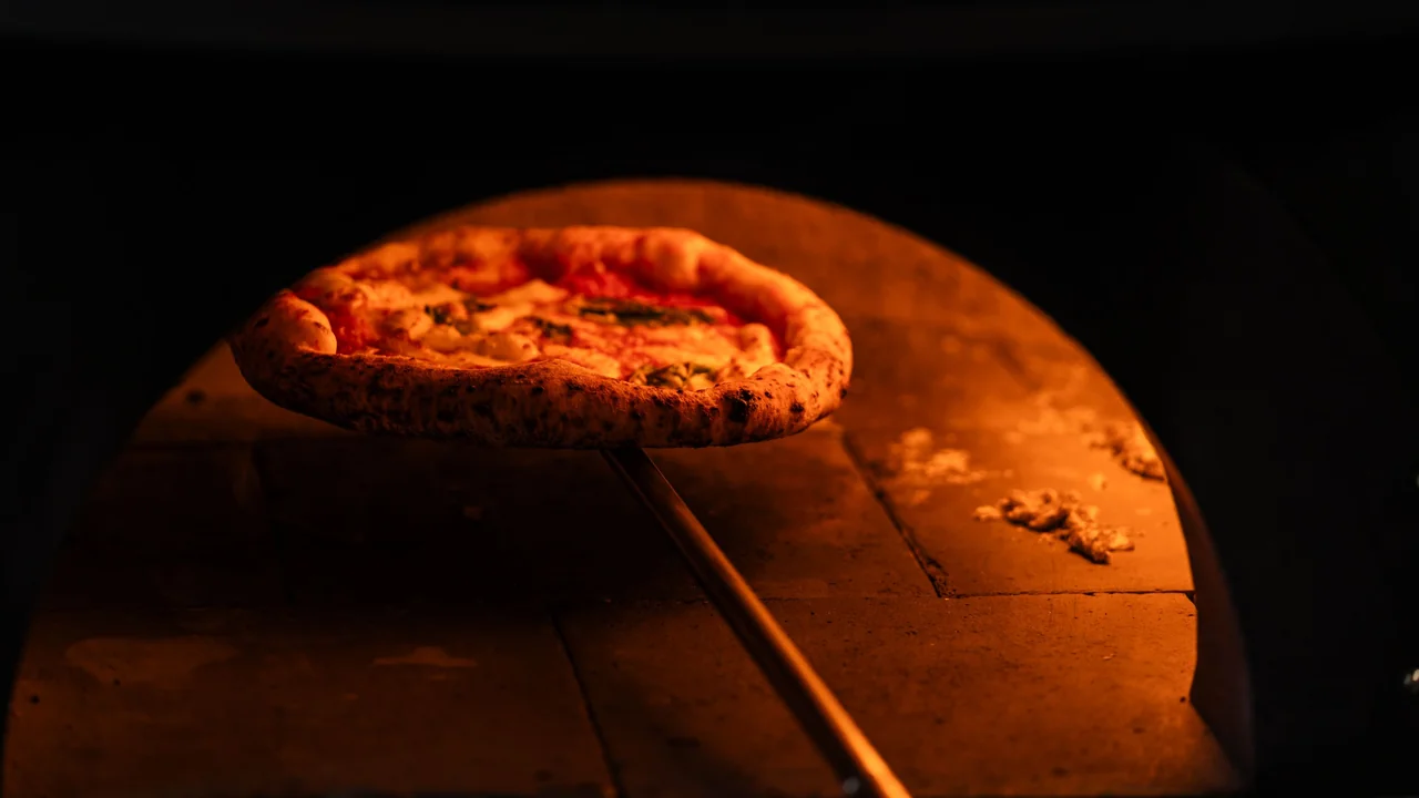 Traditional pizza baking inside the wood-fired stone oven