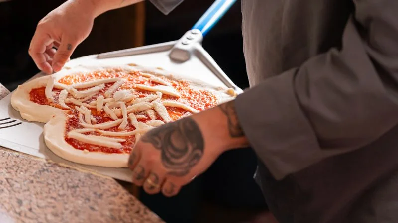 Fresh mozzarella cheese cubes layered onto pizza dough